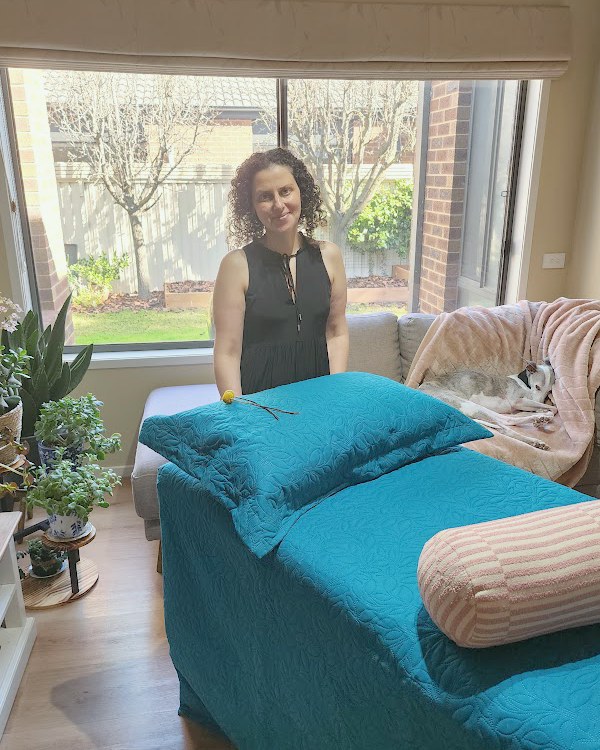 Marie beside the Reiki treatment table in her light filled room